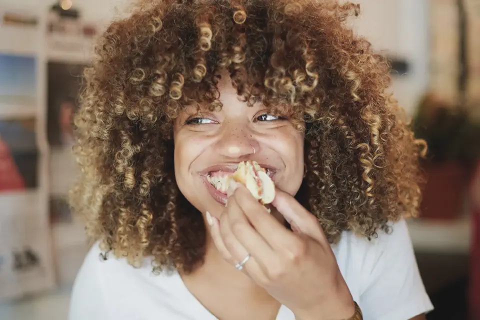 Girl eating sandwich while smiling